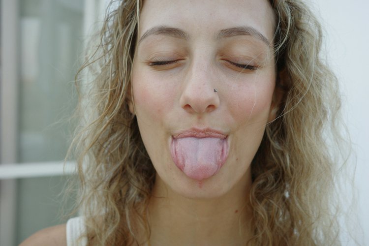 A woman with her tongue out, as for an Ayurvedic tongue analysis
